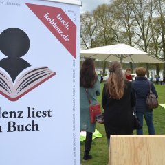 Links steht ein Roll-Up-Poster mit dem Logo von Koblenz liest ein Buch. Rechts stehen Menschen auf der Wiese vor dem Schloss und lauschen der Leserin.