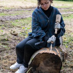 Eine Teilnehmerin bearbeitet Ihren Holzstamm